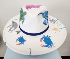 a white hat with blue crabs and other sea creatures on it's brim