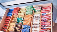 a shelf filled with lots of different types of chips and snacks on it's sides