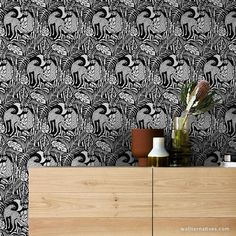 a black and white wallpaper with flowers in vases on top of a wooden cabinet