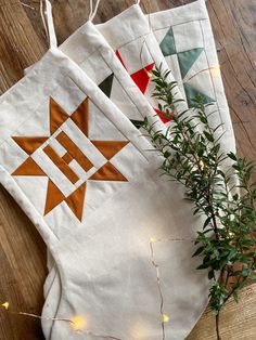 three quilted bags sitting on top of a wooden floor next to a potted plant