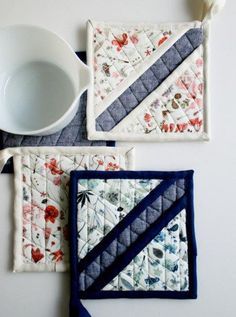 three pieces of quilted placemats on top of each other with a cup and spoon in the middle