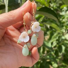 Elevate your style with our cute and delicate Spring Green Dangle Earrings. Adorned with white shell flowers, these lightweight and versatile dangles add a touch of nature-inspired elegance. Perfect for both casual and special occasions, they complement any outfit effortlessly. Whether it's a springtime brunch, garden party, or even a beach wedding, these earrings are a must-have. They also make a wonderful gift for holidays like Mother's Day, birthdays, or anniversaries. Surprise your loved ones, friends, or even treat yourself to these charming earrings that capture the essence of beauty and grace. Elegant Flower Jewelry For Summer, Elegant Summer Flower Jewelry, Elegant Summer Gift Flower Earrings, Elegant Summer Flower Earrings For Gift, Elegant Summer Flower Earrings As Gift, Feminine Spring Dangle Earrings, Spring Feminine Dangle Jewelry, Feminine Spring Dangle Jewelry, Elegant Flower Shaped Jewelry For Summer