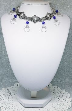 Victorian Gothic metal choker with crescent moon charms and blue crystal beads, ornate metal necklace, Victorian jewelry, Gothic jewelry A beautifully ornate gothic silver metal choker with Victorian crescent moon charms and blue faceted crystal beads. It measures approx. 11 inches in length and has lobster clasp fastening and an extension chain, so that it can be adjusted to fit the neck. The choker is made up of 7 silver toned metal ancient style sections that have intricate detailing. A marve Blue Gothic Metal Necklace, Gothic Blue Metal Jewelry, Blue Gothic Metal Jewelry, Fantasy Festival Choker Jewelry, Silver Festival Choker With Moon Charm, Gothic Festival Jewelry With Moon Charm, Fantasy Silver Jewelry With Moon Charm, Bohemian Silver Choker With Jewels, Ornate Metal Choker Jewelry