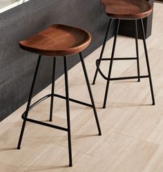 two wooden stools sitting next to each other on top of a hard wood floor