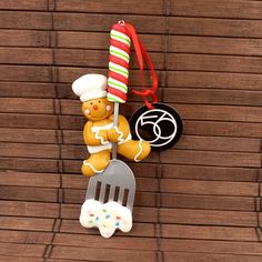 a christmas ornament with a teddy bear holding a fork and a spatula