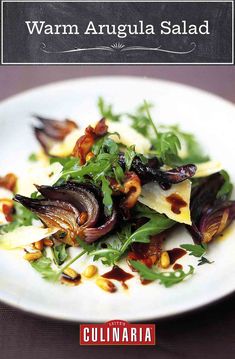 a white plate topped with greens and nuts