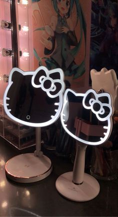 two hello kitty lighted mirrors in front of a mirror with an anime character on it