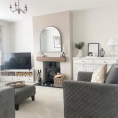 a living room filled with furniture and a flat screen tv on top of a fireplace