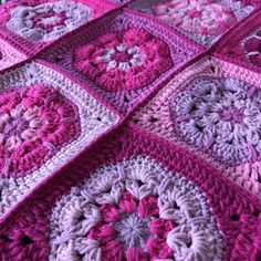 a crocheted blanket with pink and purple squares