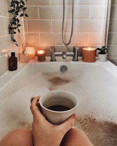 someone is sitting in the bathtub with their feet on the edge of the tub