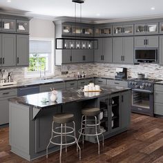 a large kitchen with gray cabinets and wooden floors