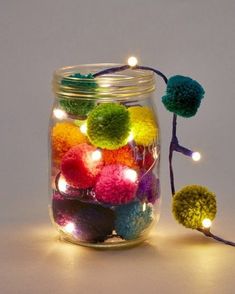 a jar filled with pom - poms and lights