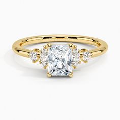 a yellow gold ring with a princess cut diamond surrounded by three smaller round brilliant diamonds