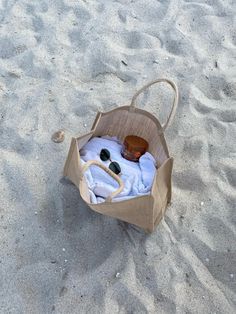 an empty bag on the sand with sunglasses in it