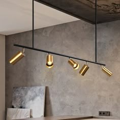 four lights are hanging from the ceiling in a room with concrete walls and flooring