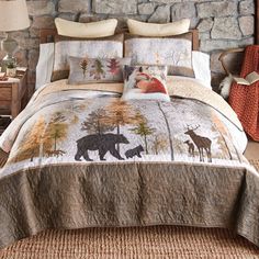 a bed with a bear and deer design on it in a room next to a stone wall