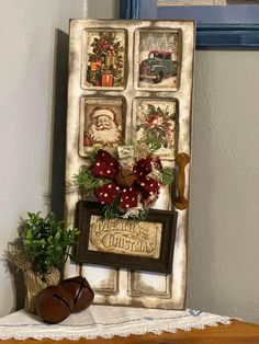 an old fashioned christmas card board is displayed on a table next to a potted plant