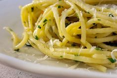 a white plate topped with pasta and parmesan cheese