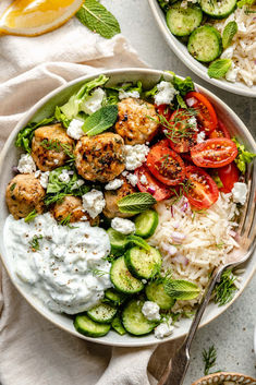 two bowls filled with different types of food and garnished with cucumbers