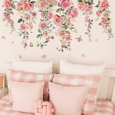 a bed with pink flowers on the wall behind it and a checkered comforter