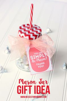 a mason jar gift idea with a pink and white striped straw sticking out of it