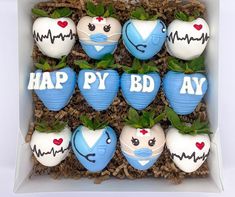 a box filled with blue and white decorated strawberries that say happy bd day