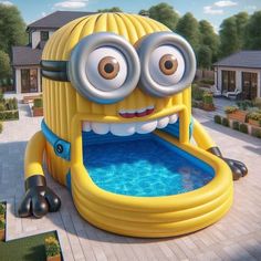 an inflatable character with large eyes sitting on the ground next to a pool