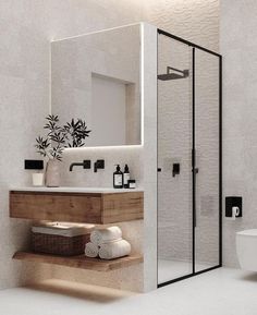 a bathroom with a toilet, sink, and shower stall in white tiles on the walls