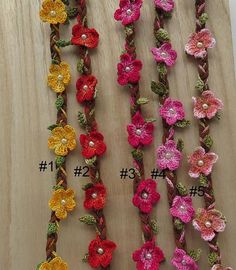 several crocheted flowers are displayed on a wooden surface with the numbers 1 - 3