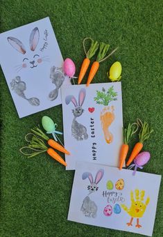 two easter cards with handprints and carrots on them, sitting on the grass