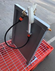 an electronic device is sitting on top of a red cart with wires attached to it