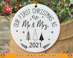 a christmas ornament hanging from a tree in a burlock with the words our first christmas mr and mrs on it