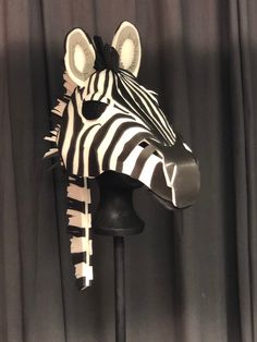 a zebra head on top of a black stand