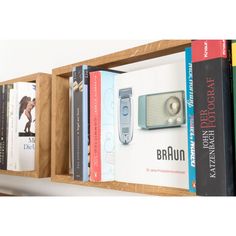 some books are sitting on a shelf next to each other and there is a radio in the middle