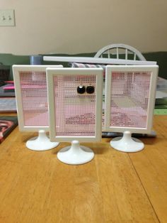 two computer screens sitting on top of a wooden table next to each other with eyeballs in them