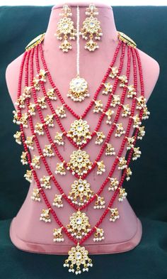 Kundan Long Red 5 Layers Necklace Earrings Tika Pearls Jewelry, Gold Plated Indian Jewelry, Bridal Wedding Handmade Jewelry Unique Set ITEM DESCRIPTION Metal = Gold Plated Occasion = Wedding ,Party Wear, Bridal Color = White and Red Size = Necklace Length = 36 CM Earrings/Studs = 7 CM Tika = 10 CM 100% Satisfaction Guarantee: 1 Year Warranty, Long Lasting Plating, High-Quality Stones Occasion: Perfect choice for any Indian occasion. Care: It is advisable that you keep products away from direct h Red Tilla Bridal Sets For Marriage, Red Bridal Sets With Tilla For Marriage, Red Kundan Jewelry For Marriage, Red Tilla Jewelry For Marriage, Red Stone Work Bridal Sets For Wedding, Bollywood Style Red Jewelry For Marriage, Traditional Red Jewelry For Wedding, Red Bridal Sets With Stone Work For Marriage, Red Temple Jewelry For Marriage