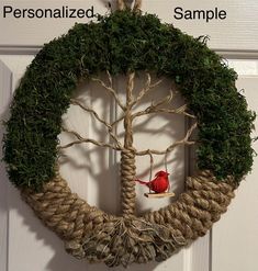 a red bird sitting on top of a roped wreath with the words personalized sample