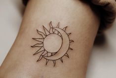 a small sun and moon tattoo on the ankle