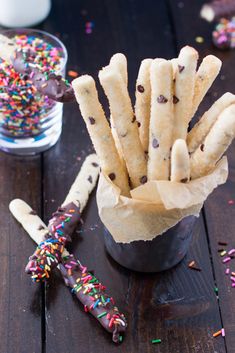 chocolate chip cookies and sprinkles are in a cup on a wooden table