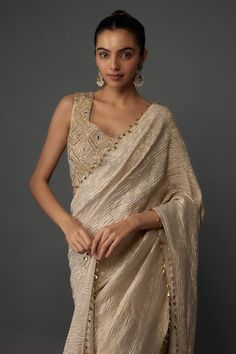 Gold pre-draped and textured saree with gold toned accents. Paired with a blouse with geometric hand embroidery. - Aza Fashions Gold Pre-draped Saree For Party, Elegant Draped Blouse For Reception, Elegant Draped Cutdana Blouse Piece, Gold Self-design Pre-draped Saree For Reception, Elegant Draped Blouse Piece With Cutdana, Raw Silk Pre-draped Saree For Reception, Reception Raw Silk Pre-draped Saree With Self Design, Gold Pre-draped Saree With Zari Work, Festive Raw Silk Draped Saree