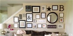 a living room filled with lots of framed pictures on the wall next to a couch