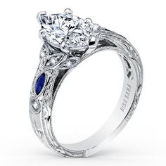 a diamond and blue sapphire engagement ring with filigrees on the band, set in white gold