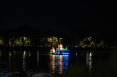 a boat that is floating in the water at night with lights on it's side