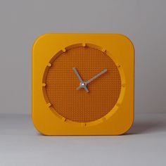 an orange clock sitting on top of a table