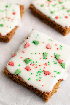 three square pieces of cake with white frosting and sprinkles on top