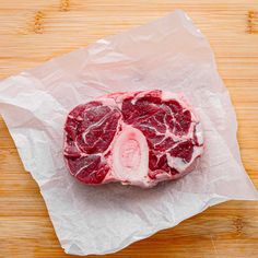 a piece of raw meat sitting on top of a wooden cutting board