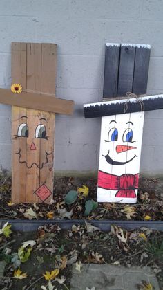 two wooden scarecrows sitting next to each other