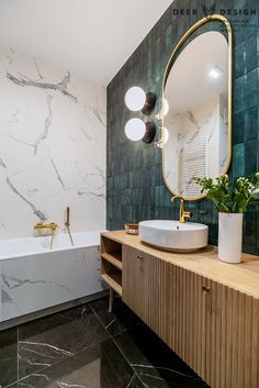 a bathroom with marble walls and flooring next to a bathtub, sink and mirror