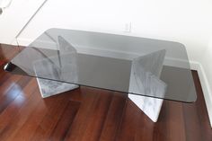 a glass table sitting on top of a wooden floor