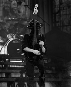 a man with a guitar on his head is standing in front of a stage set